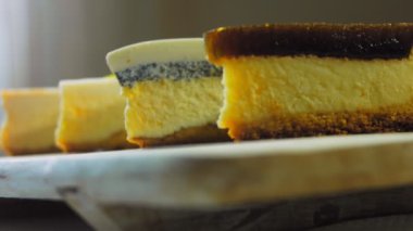 Arka arkaya dizilmiş dört çeşit cheesecake. Kaypak ve makro atış. Bir retro stil pişirme tahtası kullanılır.