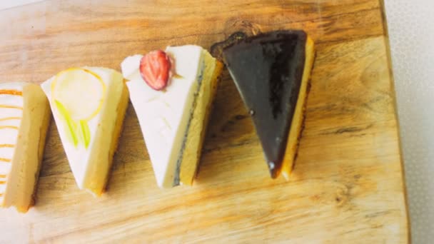 4種類のチーズケーキが並びます スライダーとマクロ撮影 レトロ調の料理板を使用 — ストック動画