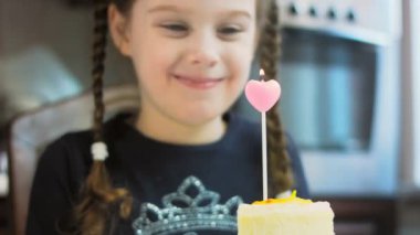 Retro tabakta limonlu cheesecake. Altın çatal ve bıçak kullan. Kadın kalp şeklindeki mumu kibritle yakıyor. Doğum gününü kutluyoruz..