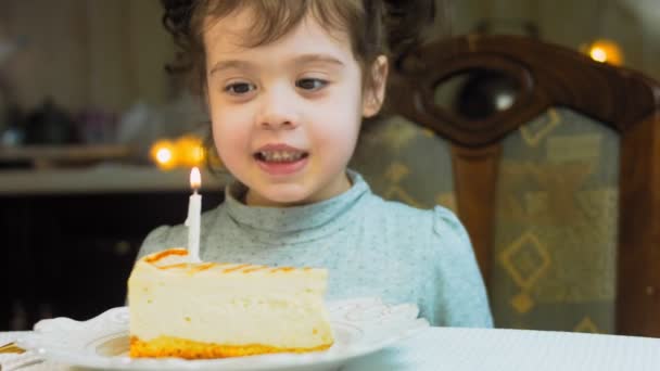 レトロなプレートにキャラメルチーズケーキ 金のフォークとナイフを使用してください ケーキの上の燃えるろうそくを消しなさい 誕生日を祝います — ストック動画