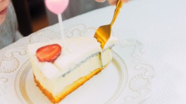 Retro tabakta çilekli panna cotta cheesecake. Altın çatal ve bıçak kullan. Kız çatalla bir parça kek yiyor. Arka plandaki kız eğleniyor. Kutlama yapıyoruz.
