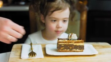 Eski usul bir pasta tepsisinde bir sürü pasta dilimi. Şef, kızların tatmasına farklı türde pasta getiriyor. Pelerinli kız pastayı sevmediğini gösteriyor..