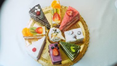 Altın tepside farklı keklerin parçaları. Kaydırıcı ve makro atış.