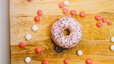 Tatlılarla süslenmiş pembe çörekler. Makro ve kaydırma atışı. Tatlı, jöleli tatlılar. Fırın ve yemek konsepti. Çeşitli renkli çörekler. Çikolata, pembe, mavi çörekler 4K, UHD.