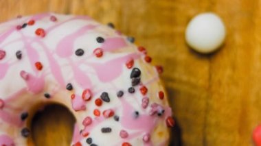 Tatlılarla süslenmiş pembe çörekler. Makro ve kaydırma atışı. Tatlı, jöleli tatlılar. Fırın ve yemek konsepti. Çeşitli renkli çörekler. Çikolata, pembe, mavi çörekler 4K, UHD.