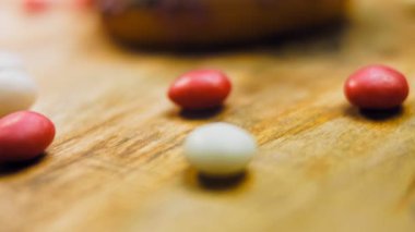 Tatlılarla süslenmiş pembe çörekler. Makro ve kaydırma atışı. Tatlı, jöleli tatlılar. Fırın ve yemek konsepti. Çeşitli renkli çörekler. Çikolata, pembe, mavi çörekler 4K, UHD.