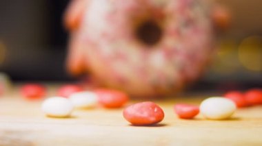 Tatlılarla süslenmiş pembe çörekler. Makro ve kaydırma atışı. Tatlı, jöleli tatlılar. Fırın ve yemek konsepti. Çeşitli renkli çörekler. Çikolata, pembe, mavi çörekler 4K, UHD.