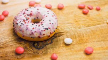 Tatlılarla süslenmiş pembe çörekler. Makro ve kaydırma atışı. Tatlı, jöleli tatlılar. Fırın ve yemek konsepti. Çeşitli renkli çörekler. Çikolata, pembe, mavi çörekler 4K, UHD.