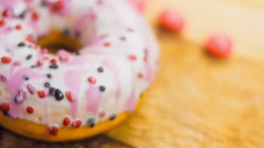 Tatlılarla süslenmiş pembe çörekler. Makro ve kaydırma atışı. Tatlı, jöleli tatlılar. Fırın ve yemek konsepti. Çeşitli renkli çörekler. Çikolata, pembe, mavi çörekler 4K, UHD.