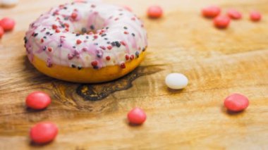 Tatlılarla süslenmiş pembe çörekler. Makro ve kaydırma atışı. Tatlı, jöleli tatlılar. Fırın ve yemek konsepti. Çeşitli renkli çörekler. Çikolata, pembe, mavi çörekler 4K, UHD.