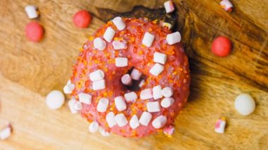 Marshmello ile süslenmiş pembe çörekler. Makro ve kaydırma atışı. Fırın ve yemek konsepti. Çeşitli renkli çörekler. Çikolata, pembe, mavi çörekler 4K, UHD.