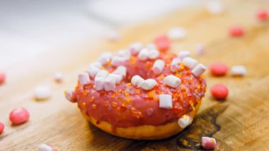 Marshmello ile süslenmiş pembe çörekler. Makro ve kaydırma atışı. Fırın ve yemek konsepti. Çeşitli renkli çörekler. Çikolata, pembe, mavi çörekler 4K, UHD.