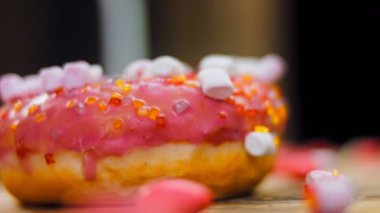 Marshmello ile süslenmiş pembe çörekler. Makro ve kaydırma atışı. Fırın ve yemek konsepti. Çeşitli renkli çörekler. Çikolata, pembe, mavi çörekler 4K, UHD.