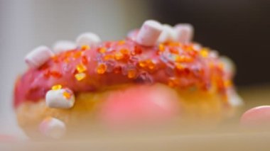 Marshmello ile süslenmiş pembe çörekler. Makro ve kaydırma atışı. Fırın ve yemek konsepti. Çeşitli renkli çörekler. Çikolata, pembe, mavi çörekler 4K, UHD.