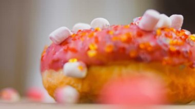 Marshmello ile süslenmiş pembe çörekler. Makro ve kaydırma atışı. Fırın ve yemek konsepti. Çeşitli renkli çörekler. Çikolata, pembe, mavi çörekler 4K, UHD.