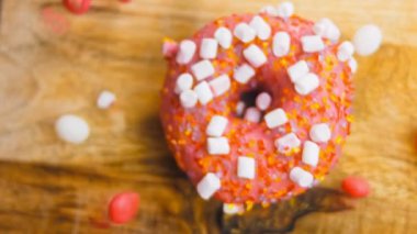 Marshmello ile süslenmiş pembe çörekler. Makro ve kaydırma atışı. Fırın ve yemek konsepti. Çeşitli renkli çörekler. Çikolata, pembe, mavi çörekler 4K, UHD.