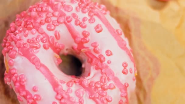도넛은 분홍색으로 장식되어 도넛은 사탕으로 장식된 있습니다 매크로와 슬라이더 사탕은 — 비디오