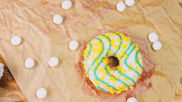 Желтые Пончики Украшенные Голубой Глазурью Пончики Клочке Бумаги Украшенном Конфетами — стоковое видео