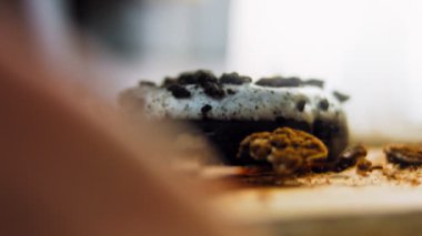 Oeo bisküvileriyle süslenmiş çikolatalı çörekler. Donutlar doğal çikolatayla süslenmiş bir kağıdın üzerinde. Makro ve kaydırma atışı. Fırın ve yemek konsepti. Çeşitli renkli çörekler. Çikolata.