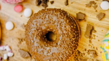 Çikolata, marşmelov ve retro pişirme tepsisindeki şekerli çörekler. Donutlar doğal çikolatayla süslenmiş bir kağıdın üzerinde. Makro ve kaydırma atışı. Çeşitli renkli çörekler. Çikolata, pembe, mavi çörekler
