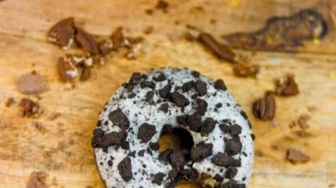 Donut 'ın ağız şeklinde bir ısırığı var. Oeo bisküvileriyle süslenmiş çikolatalı çörekler. Donutlar doğal çikolatayla süslenmiş bir kağıdın üzerinde. Makro ve kaydırma atışı. Fırın ve gıda konsepti