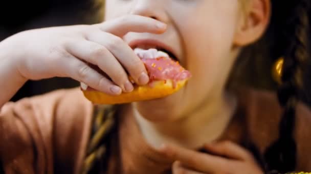 女孩吃甜甜圈 巧克力 棉花糖和糖果甜甜圈在一个复古烤盘 甜甜圈在用天然巧克力装饰的纸上 宏观和滑翔机射击 各种色彩艳丽的甜甜圈 — 图库视频影像