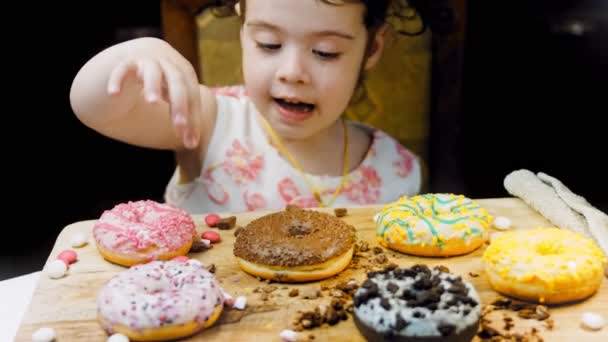 Девушка Выбирает Нескольких Подарков Показывает Пальцем Шоколад Маршмелло Шоколадные Пончики — стоковое видео