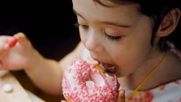 Das Mädchen Isst Donuts Schokolade Marshmello Und Bonbon Donuts Auf — Stockvideo