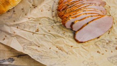 Fransız ekmeğiyle dilimlenmiş domuz filetosu. Sosis retro-stil yemek tepsisinde ve yemek kağıdında. Yavaş çekim kaydırağın üzerinde. Taze marul yaprakları da kullanıyoruz..