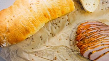 Fransız ekmeğiyle dilimlenmiş domuz filetosu. Sosis retro-stil yemek tepsisinde ve yemek kağıdında. Yavaş çekim kaydırağın üzerinde. Taze marul yaprakları da kullanıyoruz..