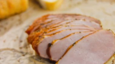 Fransız ekmeğiyle dilimlenmiş domuz filetosu. Sosis retro-stil yemek tepsisinde ve yemek kağıdında. Yavaş çekim kaydırağın üzerinde. Taze marul yaprakları da kullanıyoruz..