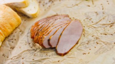 Fransız ekmeğiyle dilimlenmiş domuz filetosu. Sosis retro-stil yemek tepsisinde ve yemek kağıdında. Yavaş çekim kaydırağın üzerinde. Taze marul yaprakları da kullanıyoruz..