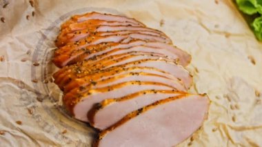 Fransız ekmeğiyle dilimlenmiş domuz filetosu. Sosis retro-stil yemek tepsisinde ve yemek kağıdında. Yavaş çekim kaydırağın üzerinde. Taze marul yaprakları da kullanıyoruz..