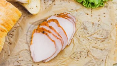 Fransız ekmeğiyle dilimlenmiş domuz filetosu. Sosis retro-stil yemek tepsisinde ve yemek kağıdında. Yavaş çekim kaydırağın üzerinde. Taze marul yaprakları da kullanıyoruz..