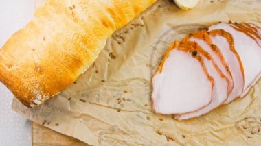 Fransız ekmeğiyle dilimlenmiş domuz filetosu. Sosis retro-stil yemek tepsisinde ve yemek kağıdında. Yavaş çekim kaydırağın üzerinde. Taze marul yaprakları da kullanıyoruz..