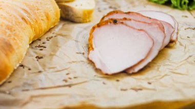 Fransız ekmeğiyle dilimlenmiş domuz filetosu. Sosis retro-stil yemek tepsisinde ve yemek kağıdında. Yavaş çekim kaydırağın üzerinde. Taze marul yaprakları da kullanıyoruz..