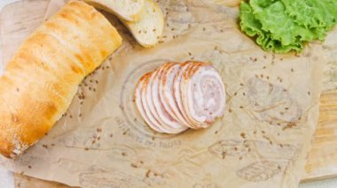 Fransız ekmeğiyle dilimlenmiş sosisli börek. Sosis retro-stil yemek tepsisinde ve yemek kağıdında. Yavaş çekim kaydırağın üzerinde. Taze marul yaprakları da kullanıyoruz..