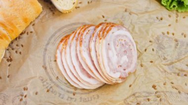 Fransız ekmeğiyle dilimlenmiş sosisli börek. Sosis retro-stil yemek tepsisinde ve yemek kağıdında. Yavaş çekim kaydırağın üzerinde. Taze marul yaprakları da kullanıyoruz..