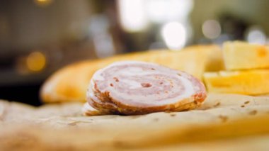 Fransız ekmeğiyle dilimlenmiş sosisli börek. Sosis retro-stil yemek tepsisinde ve yemek kağıdında. Yavaş çekim kaydırağın üzerinde. Taze marul yaprakları da kullanıyoruz..