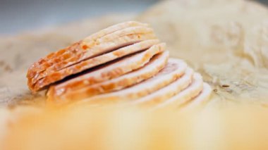 Fransız ekmeğiyle dilimlenmiş sosisli börek. Sosis retro-stil yemek tepsisinde ve yemek kağıdında. Yavaş çekim kaydırağın üzerinde. Taze marul yaprakları da kullanıyoruz..