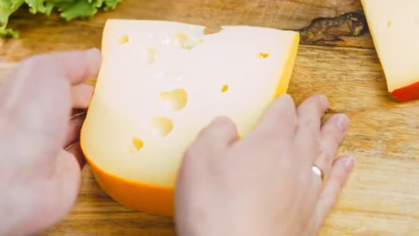 那女人手里拿着一块有孔的奶酪 滑翔机拍摄奶酪展示过程 — 图库视频影像