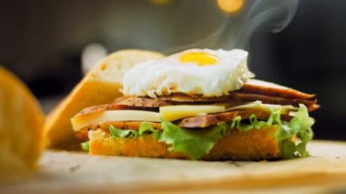 Fransız ekmeği, peynir, salata yaprakları ve sosisle sanvich 'in üzerinde kaynayan kalp şeklinde sahanda yumurta. Kaydırıcı atışı.