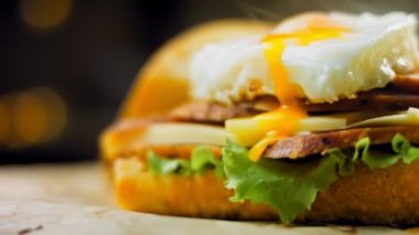 Fransız ekmeği, peynir, salata yaprakları ve sosisle sanvich 'in üzerinde kaynayan kalp şeklinde sahanda yumurta. Kaydırıcı atışı.