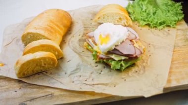 Fransız ekmeği, peynir, salata yaprakları ve sosisle sanvich 'in üzerinde kaynayan kalp şeklinde sahanda yumurta. Kaydırıcı atışı.