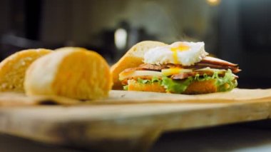 Fransız ekmeği, peynir, salata yaprakları ve sosisle sanvich 'in üzerinde kaynayan kalp şeklinde sahanda yumurta. Kaydırıcı atışı.