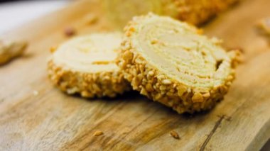 Fıstıklı kek. Arka planda retro-stil bir yemek tepsisinin üzerinde birkaç parça kek ve fıstık var. Makro ve sürgülü atış.