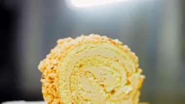 Altın çatallı bir tabakta fıstıklı kek. Arka planda retro-stil yemek tepsisi üzerinde soyulmuş fıstık var. Makro ve sürgülü atış.