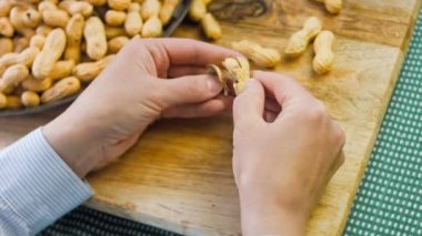 Kadın retro tepsisindeki fıstıkları soyuyor. Makro kaydırma atışı.