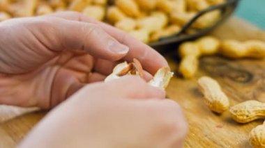 Kadın retro tepsisindeki fıstıkları soyuyor. Makro kaydırma atışı.