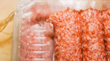 Pembe sosisli şeffaf bir kutu. Sosisler sıraya dizildi. Kaydırıcı atışı.